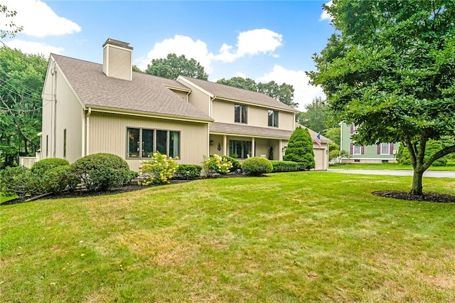 back of property featuring a yard and a garage