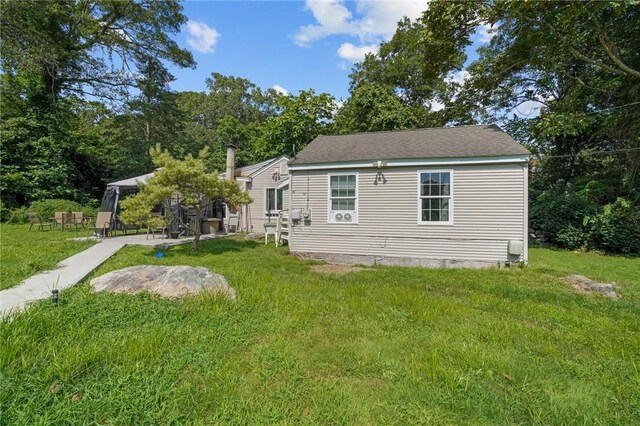 rear view of property featuring a lawn