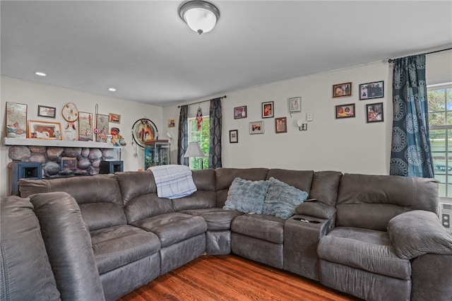 living room featuring a stone fireplace and wood-type flooring