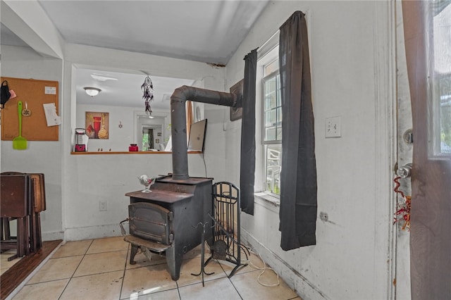 tiled dining space featuring a wood stove