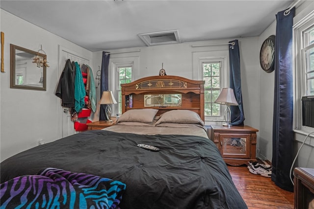 bedroom with multiple windows and hardwood / wood-style flooring