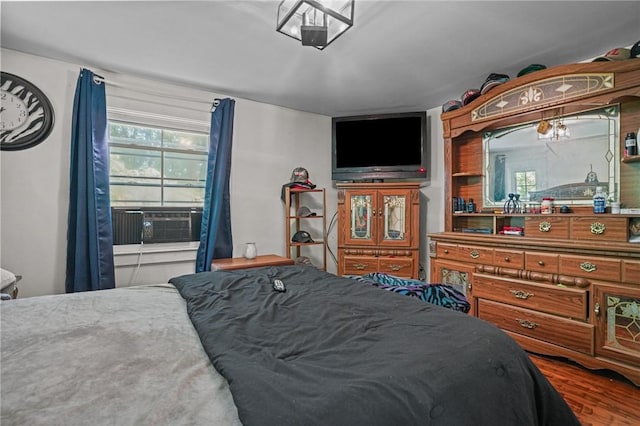 bedroom featuring cooling unit and wood finished floors