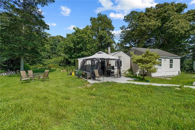 back of property featuring a patio area, a lawn, and a gazebo