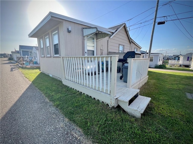 view of home's exterior featuring a lawn and a wooden deck