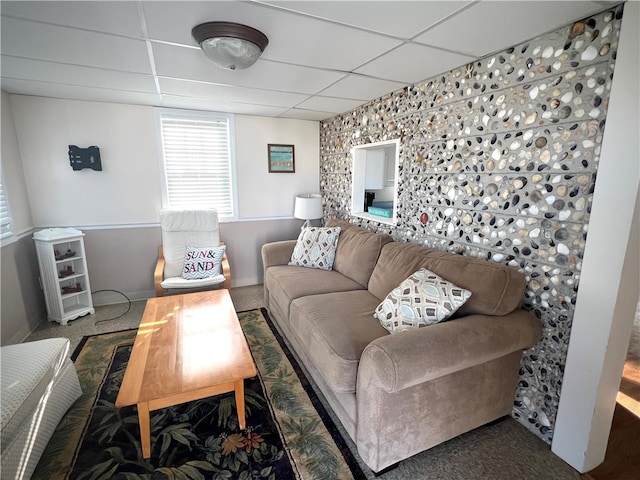 living room with carpet and a paneled ceiling