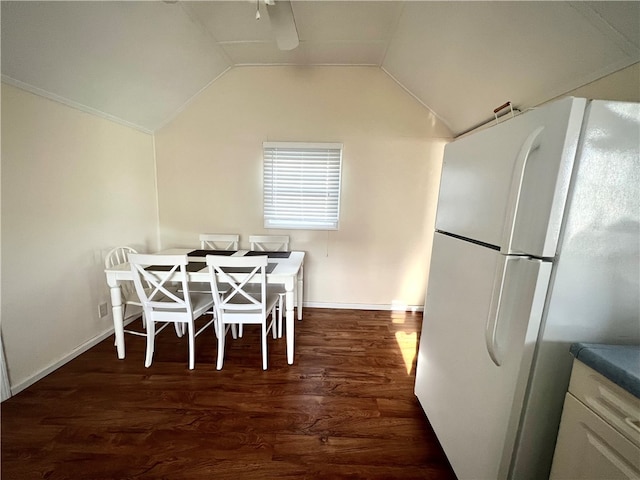 dining space with dark hardwood / wood-style floors and vaulted ceiling