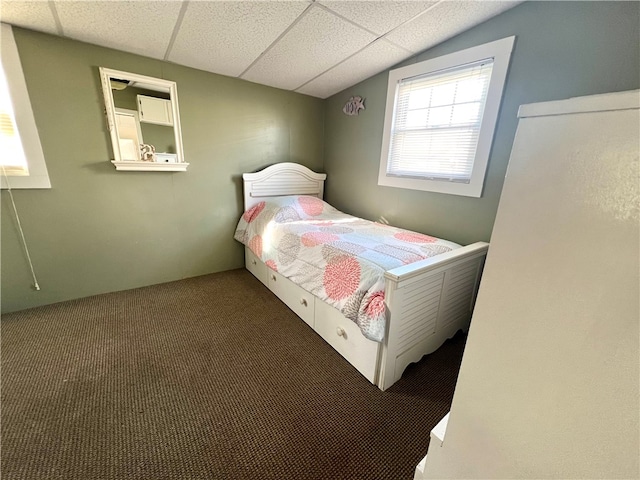 bedroom with a drop ceiling and carpet floors