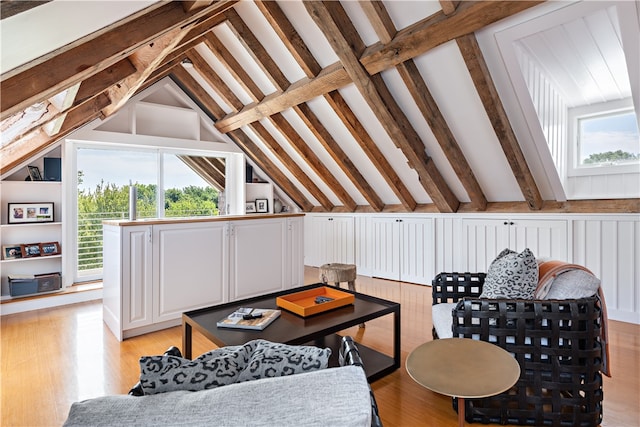 interior space featuring light wood-type flooring, vaulted ceiling with beams, and a healthy amount of sunlight