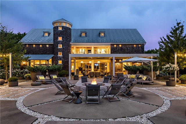 back house at dusk with a patio area