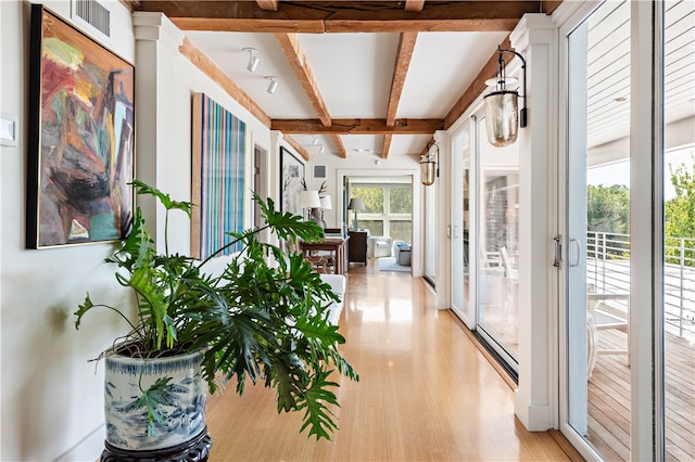 hall with beam ceiling and light hardwood / wood-style flooring