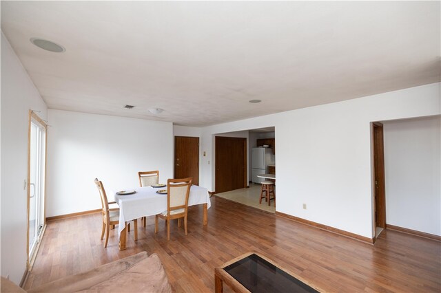 dining space with hardwood / wood-style flooring