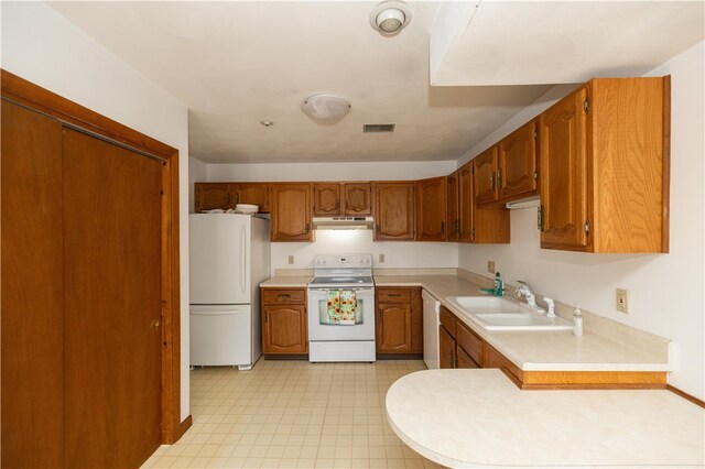 kitchen with light tile patterned flooring, sink, and white appliances