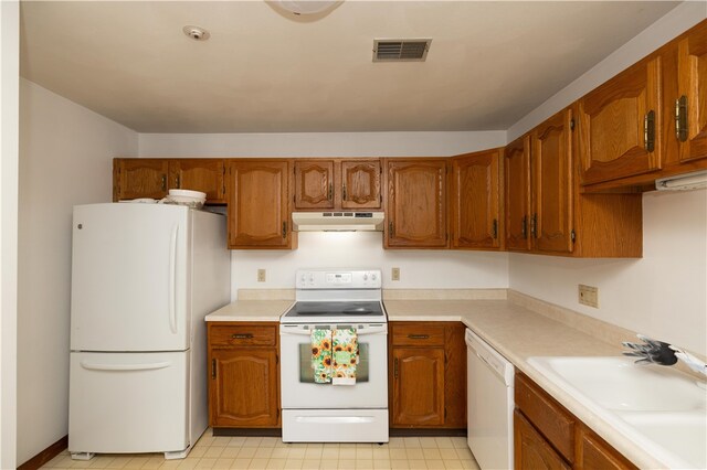 kitchen with light tile patterned floors, sink, and white appliances