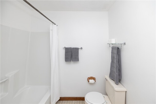 bathroom featuring toilet, shower / bath combo with shower curtain, and tile patterned floors