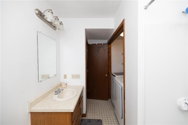 bathroom with washer and clothes dryer, vanity, and tile patterned floors