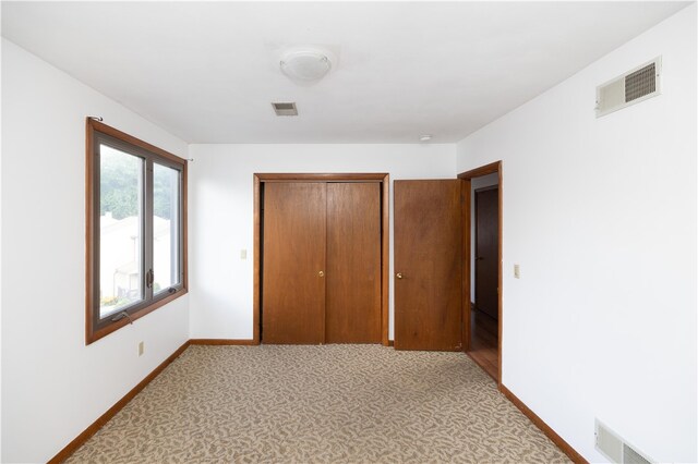 unfurnished bedroom with carpet and a closet