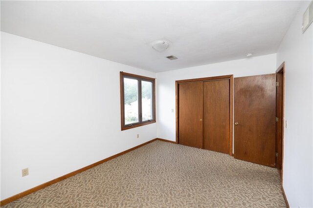 unfurnished bedroom featuring a closet and light carpet