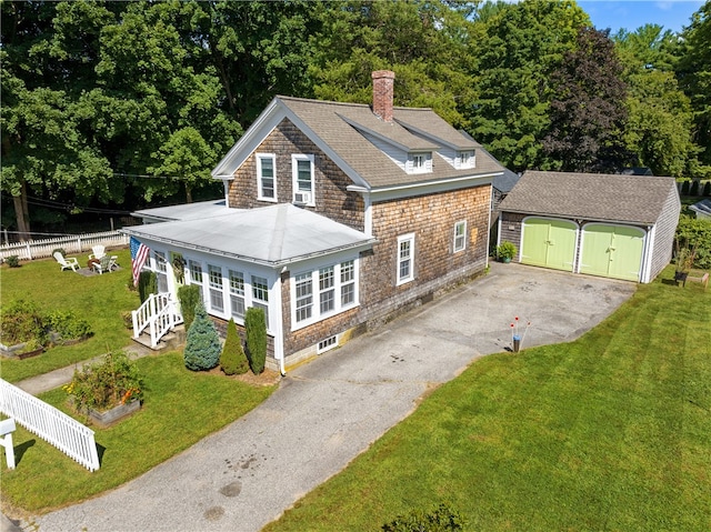 view of front property with an outbuilding, a garage, and a front lawn