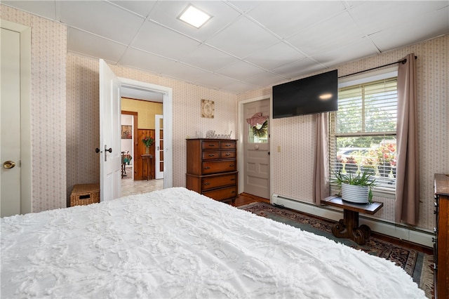 bedroom with hardwood / wood-style floors and a paneled ceiling