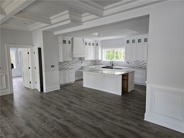 kitchen with custom range hood, sink, a center island, white cabinets, and dark hardwood / wood-style flooring