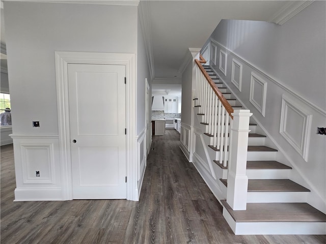 stairway featuring hardwood / wood-style floors and crown molding