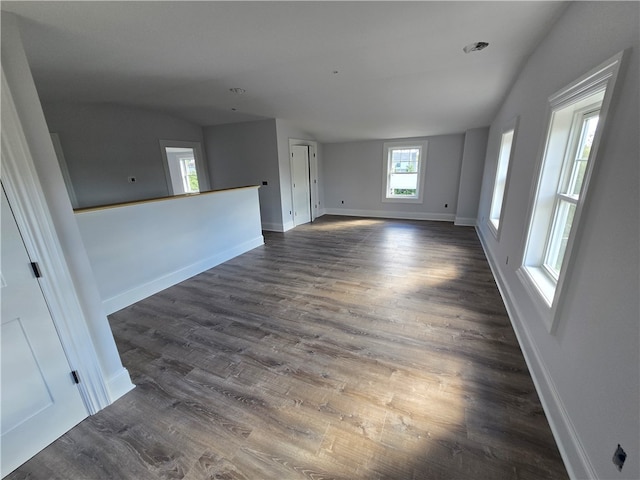 unfurnished room featuring dark hardwood / wood-style floors and vaulted ceiling