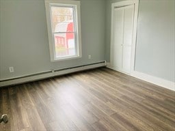 interior space featuring a baseboard heating unit and hardwood / wood-style flooring