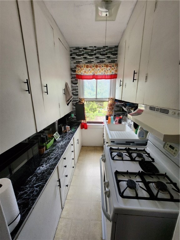 kitchen featuring white gas stove and white cabinets