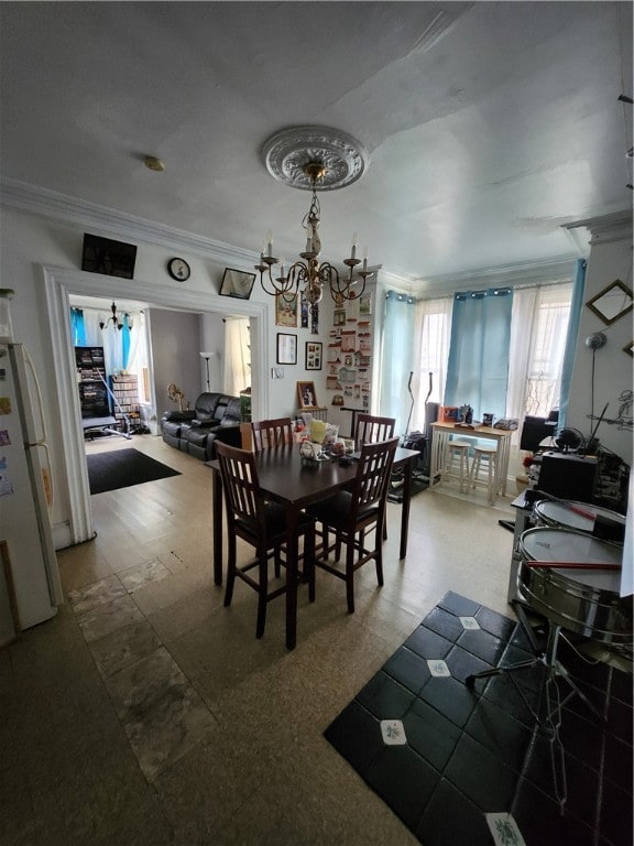 dining space with a chandelier and crown molding