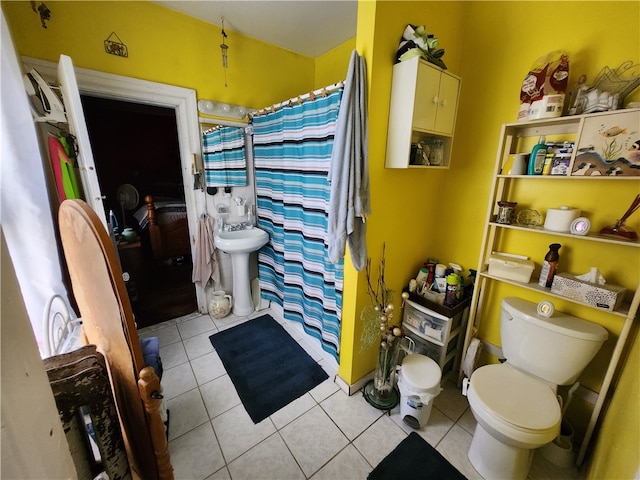 bathroom featuring toilet, sink, and tile patterned floors