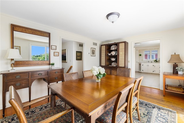 dining room featuring ornamental molding and light hardwood / wood-style flooring