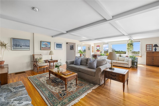 living room with light hardwood / wood-style flooring and beamed ceiling