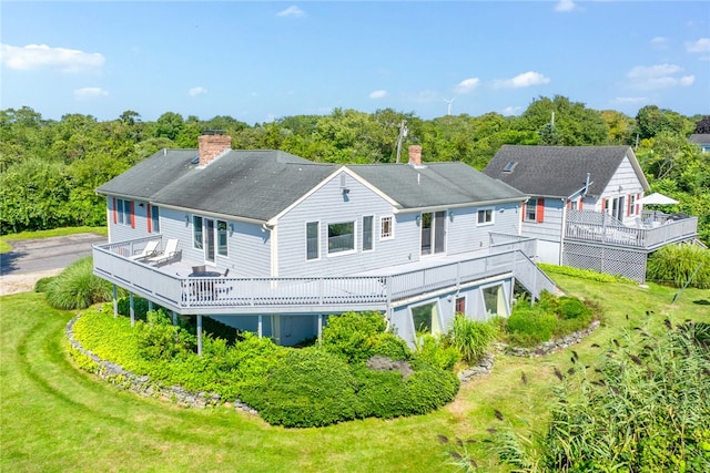 rear view of house featuring a yard and a deck