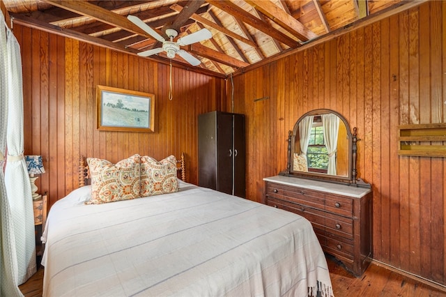 bedroom featuring wood walls, dark hardwood / wood-style floors, wooden ceiling, and lofted ceiling with beams