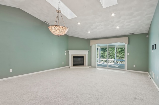 unfurnished living room with carpet flooring and lofted ceiling with skylight