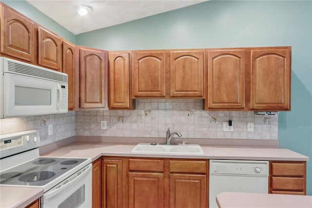 kitchen featuring white appliances, sink, decorative backsplash, and lofted ceiling