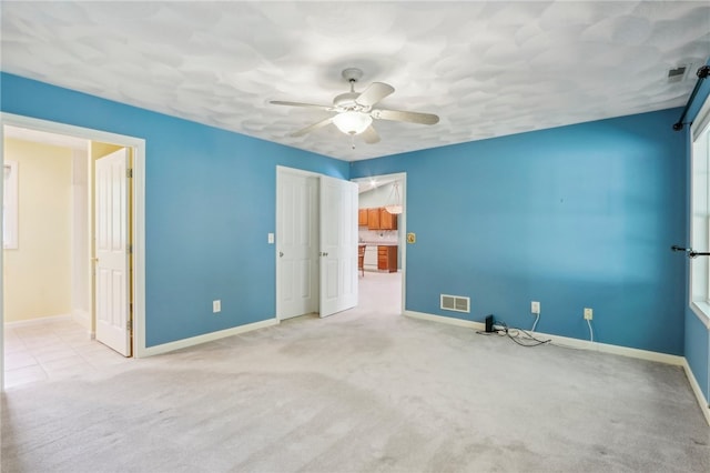 spare room featuring light carpet and ceiling fan