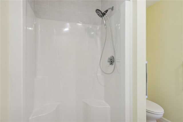 bathroom with tiled shower and toilet