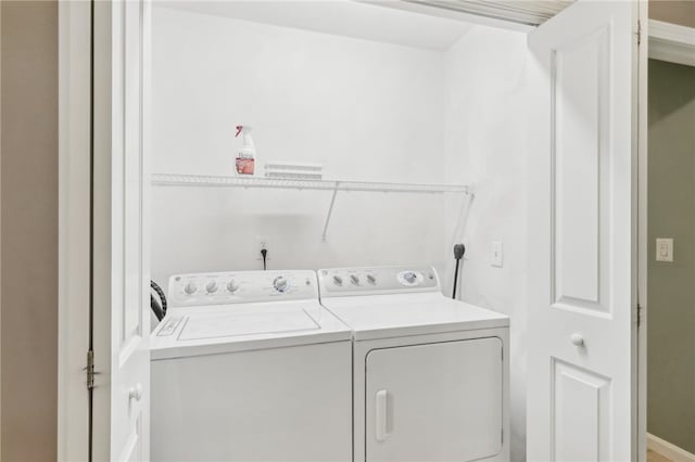 clothes washing area featuring separate washer and dryer