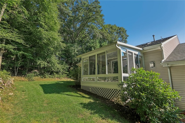 view of side of property with a lawn and a sunroom