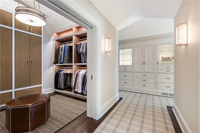 walk in closet featuring light wood-type flooring and lofted ceiling