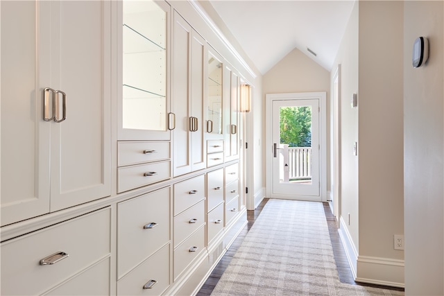 corridor featuring lofted ceiling and light hardwood / wood-style floors