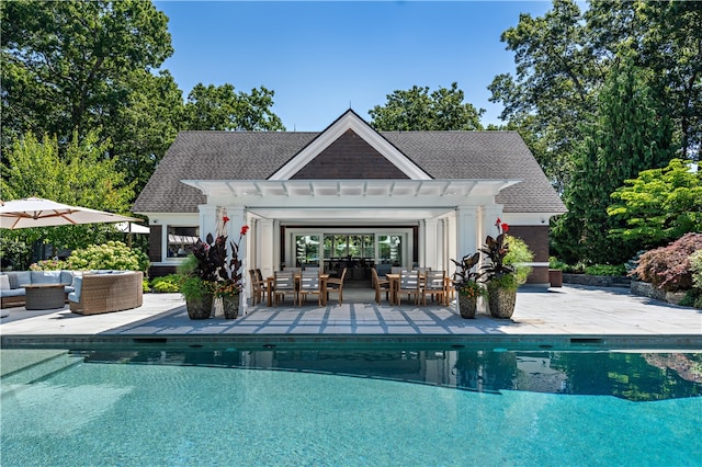 view of swimming pool featuring an outdoor hangout area, a patio area, and an outbuilding