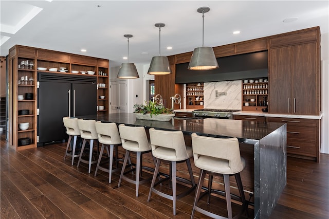 bar with tasteful backsplash, built in refrigerator, stainless steel range, premium range hood, and dark hardwood / wood-style floors