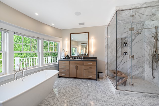 bathroom with separate shower and tub, plenty of natural light, and vanity