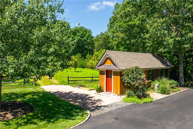 view of home's community featuring a yard and an outbuilding