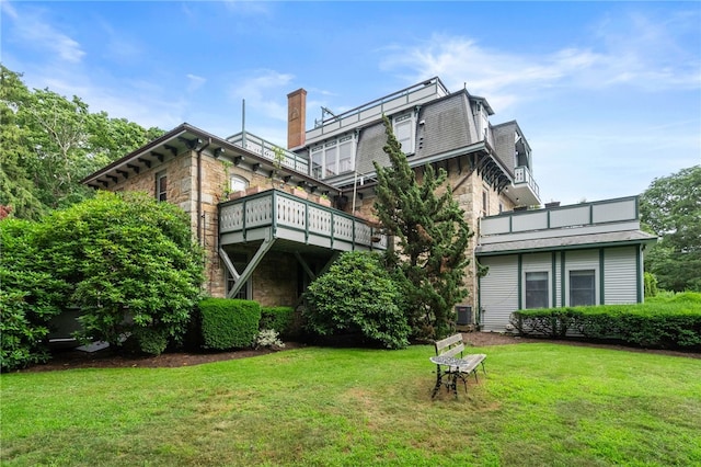 back of property featuring a lawn and central AC