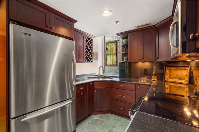 kitchen with appliances with stainless steel finishes, tasteful backsplash, and sink