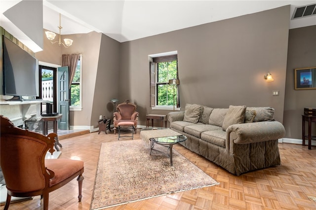 living room featuring light parquet floors and a notable chandelier