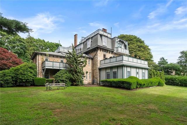 rear view of house featuring a yard and central AC